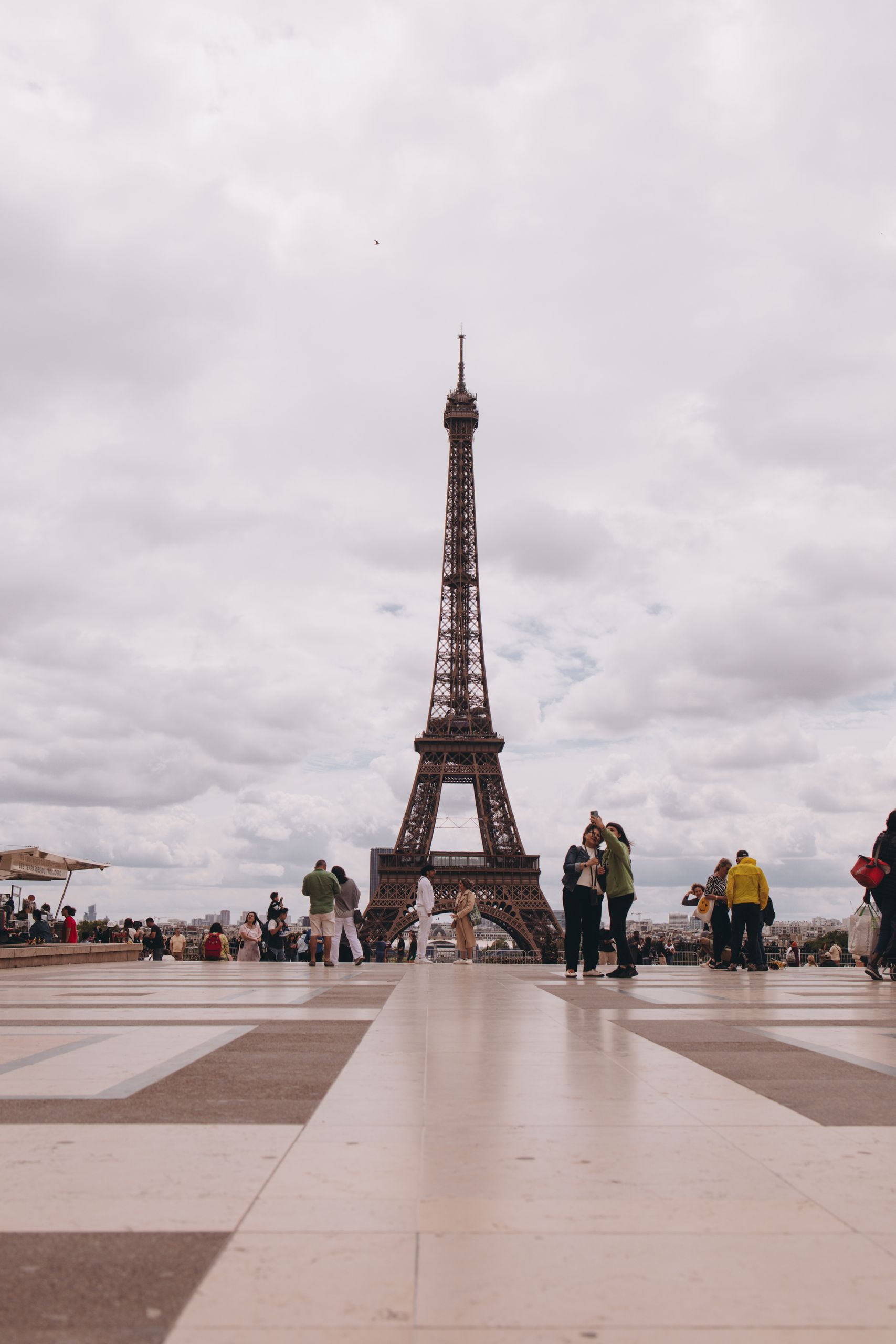 Scenic view of the Eiffel Tower with people gathering around in Paris, France.