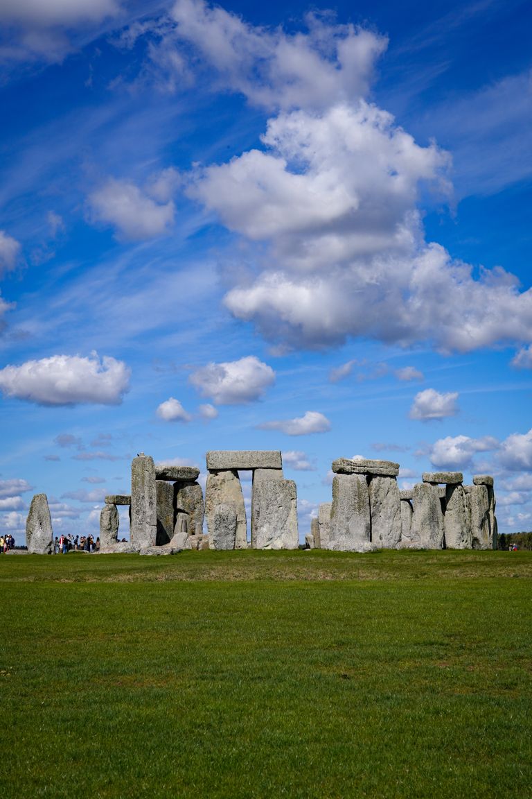Stunning Stonehenge with vibrant blue sky and green grass, capturing ancient history.