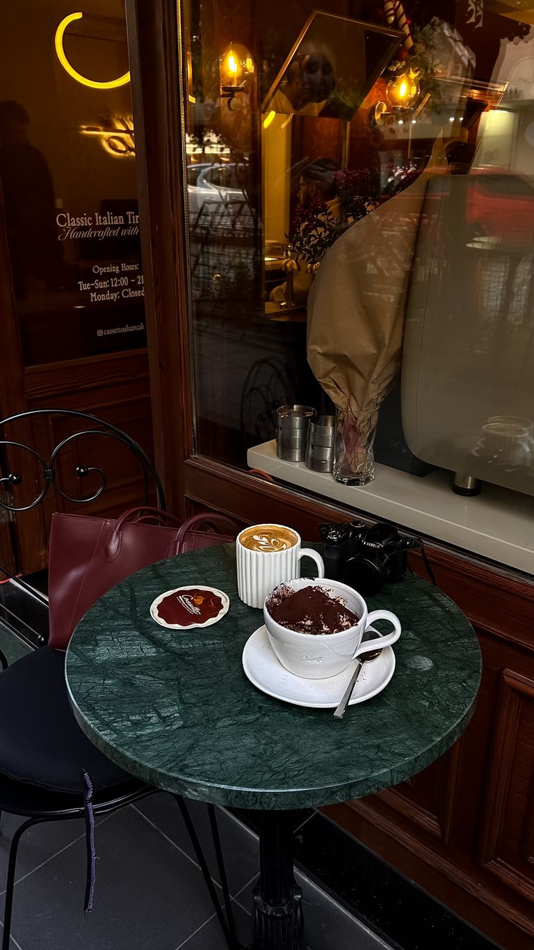 The Café That Helps a New City Feel Familiar - Warm and inviting cafe table with coffee and hot chocolate on a marble top table.