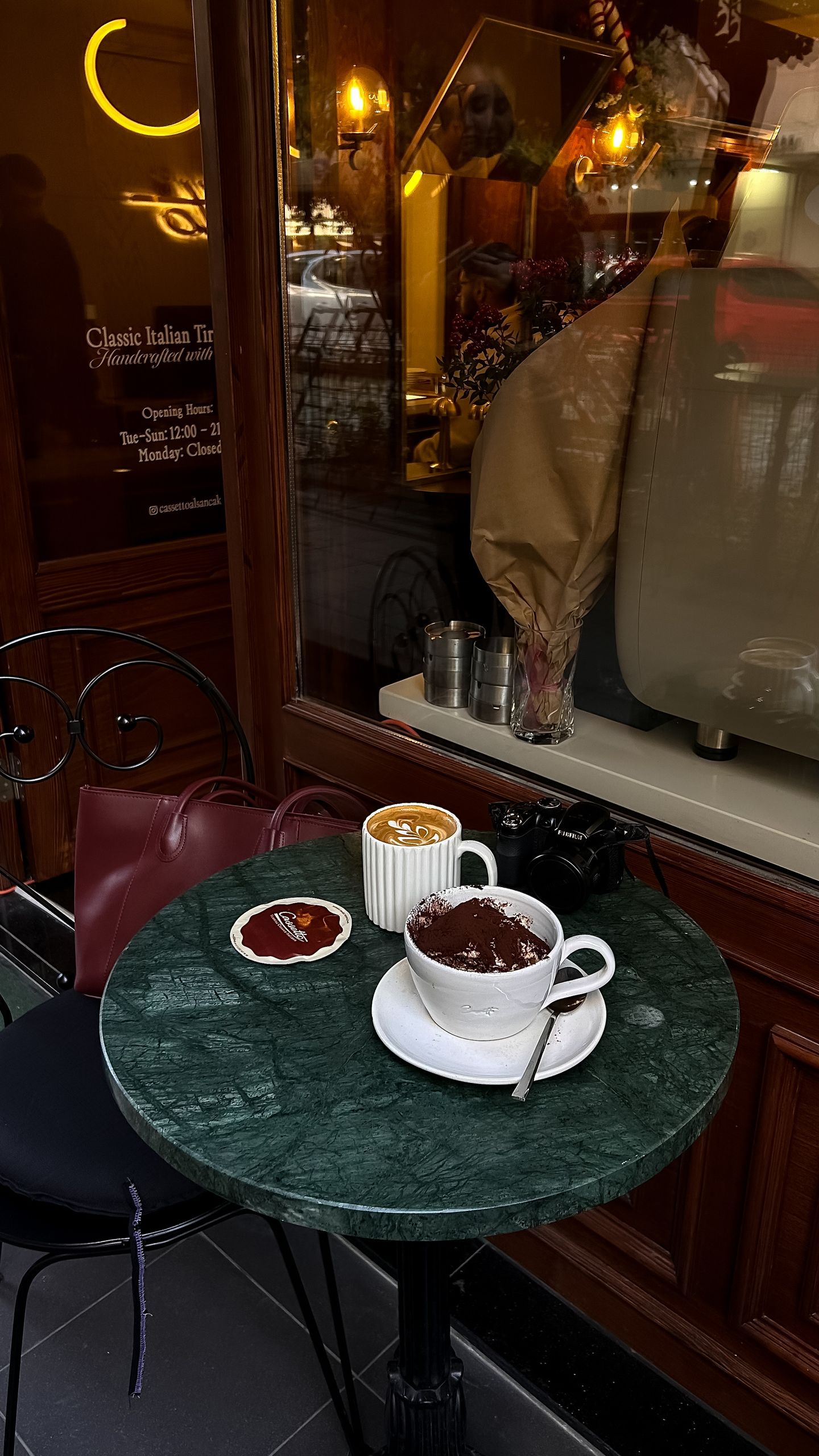 The Café That Helps a New City Feel Familiar - Warm and inviting cafe table with coffee and hot chocolate on a marble top table.