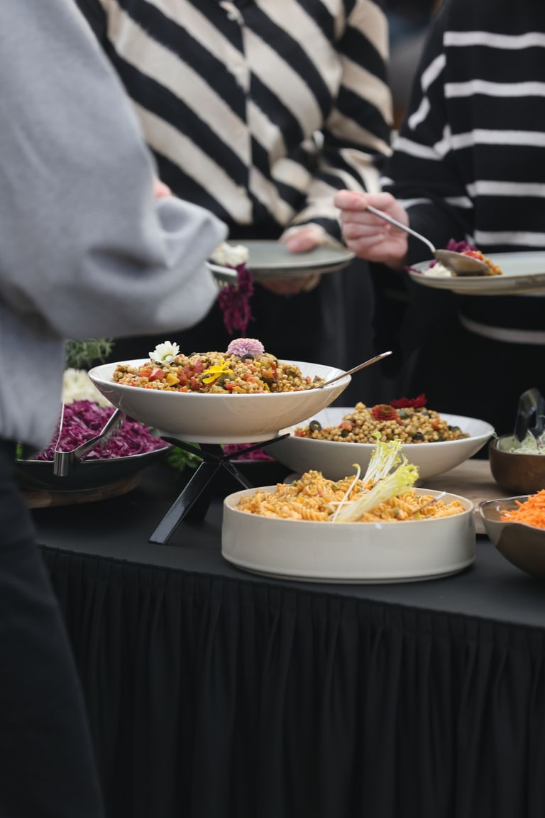 The Good Pot - A diverse array of colorful dishes on a buffet table at a gathering, featuring salads and grains.