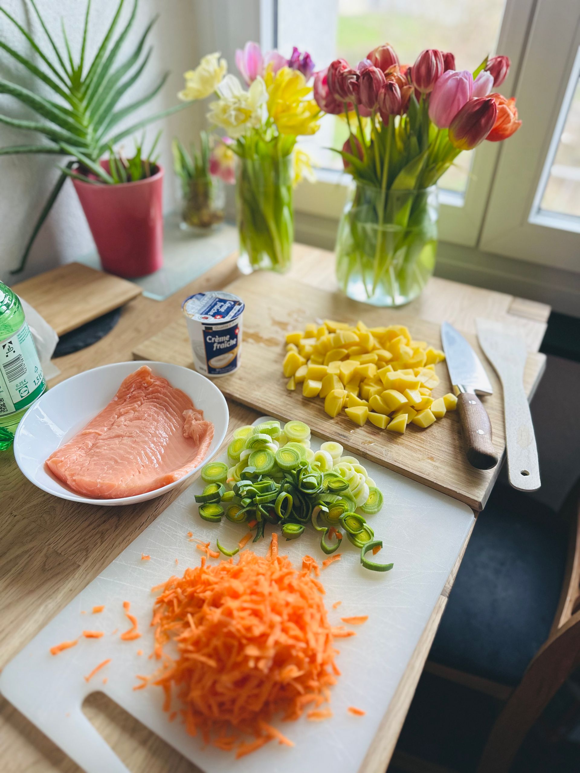 The Meal I Make When I Need to Feel Grounded - A cozy kitchen scene featuring fresh salmon, vegetables, and vibrant bouquets.