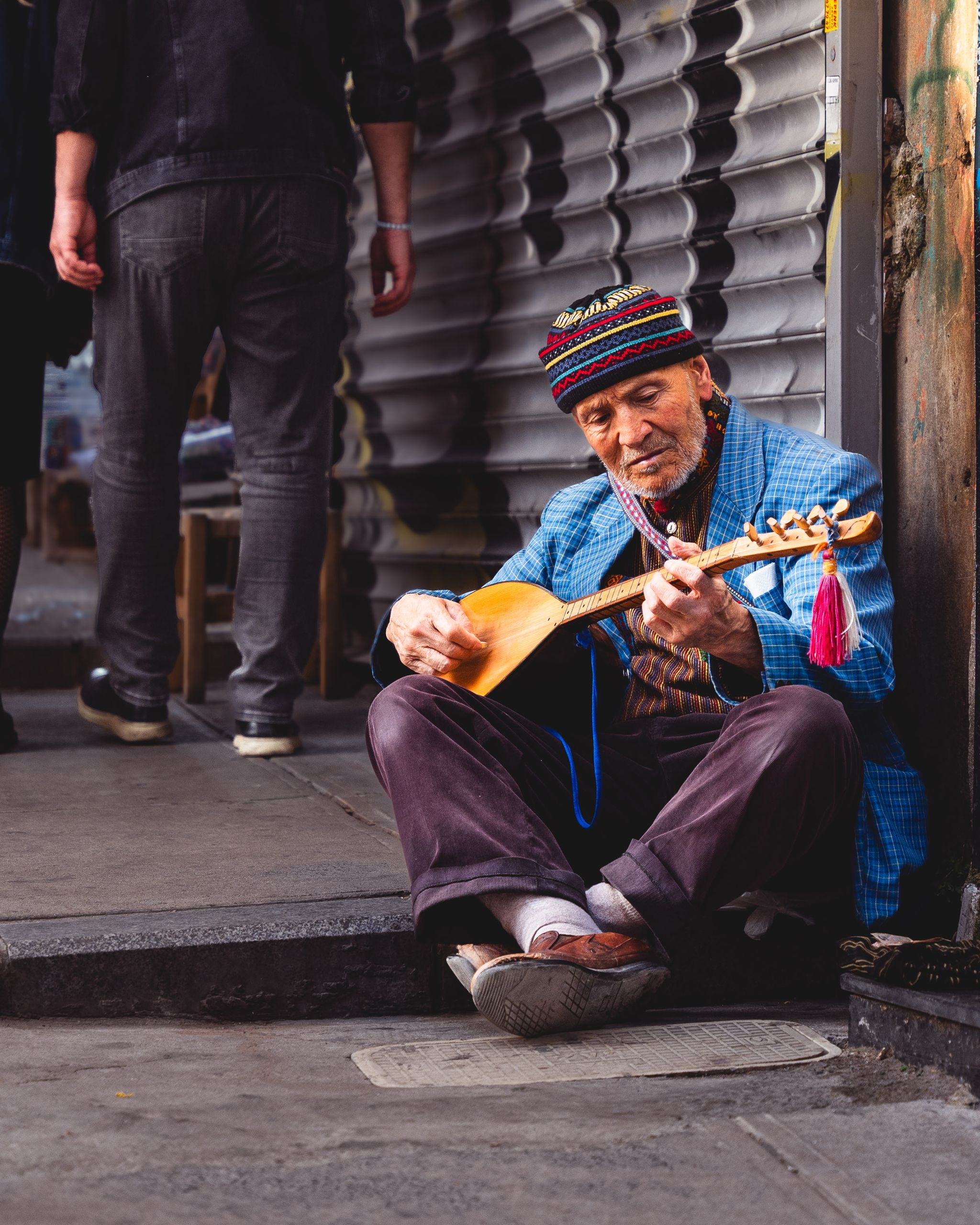 The Music I Remember Before the Landmark - An elderly musician plays a traditional string instrument on the streets of Istanbul, Türkiye.