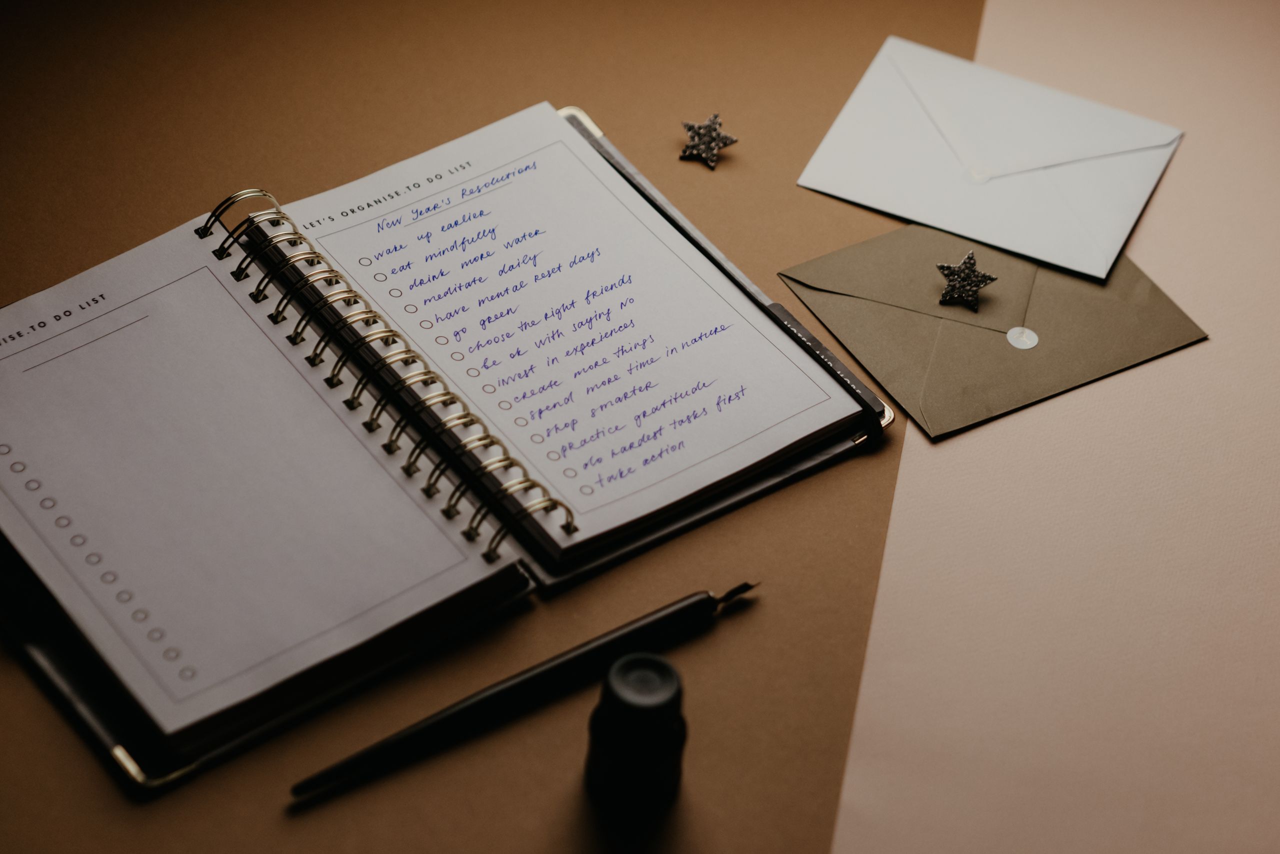 The one who remembers everything - A tidy desk setup featuring a planner, to-do list, envelopes, and a pen.