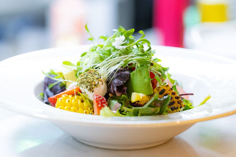 The Salad That Tastes Like the Garden Had Something to Say - Vibrant garden salad with fresh greens, vegetables, and corn in a white bowl.