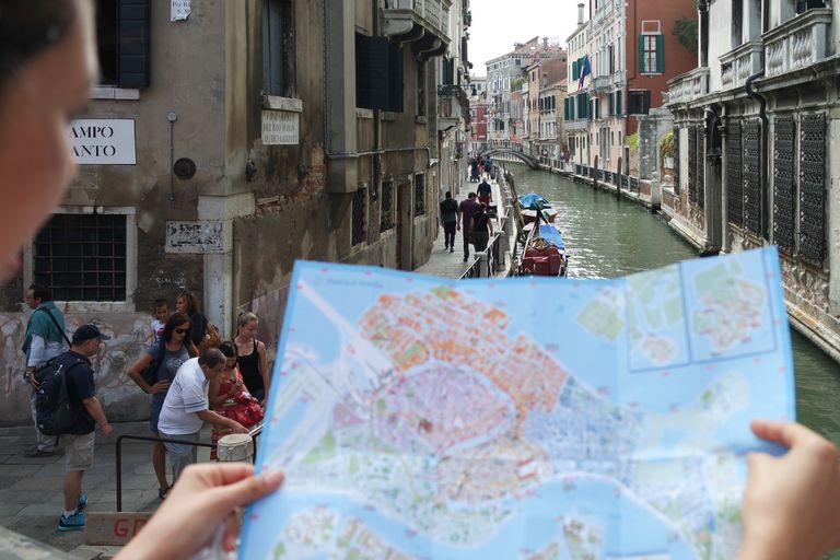 The Travel Lesson Inside a Missed Turn - Tourists exploring Venice's canals and historic streets with a map in hand.