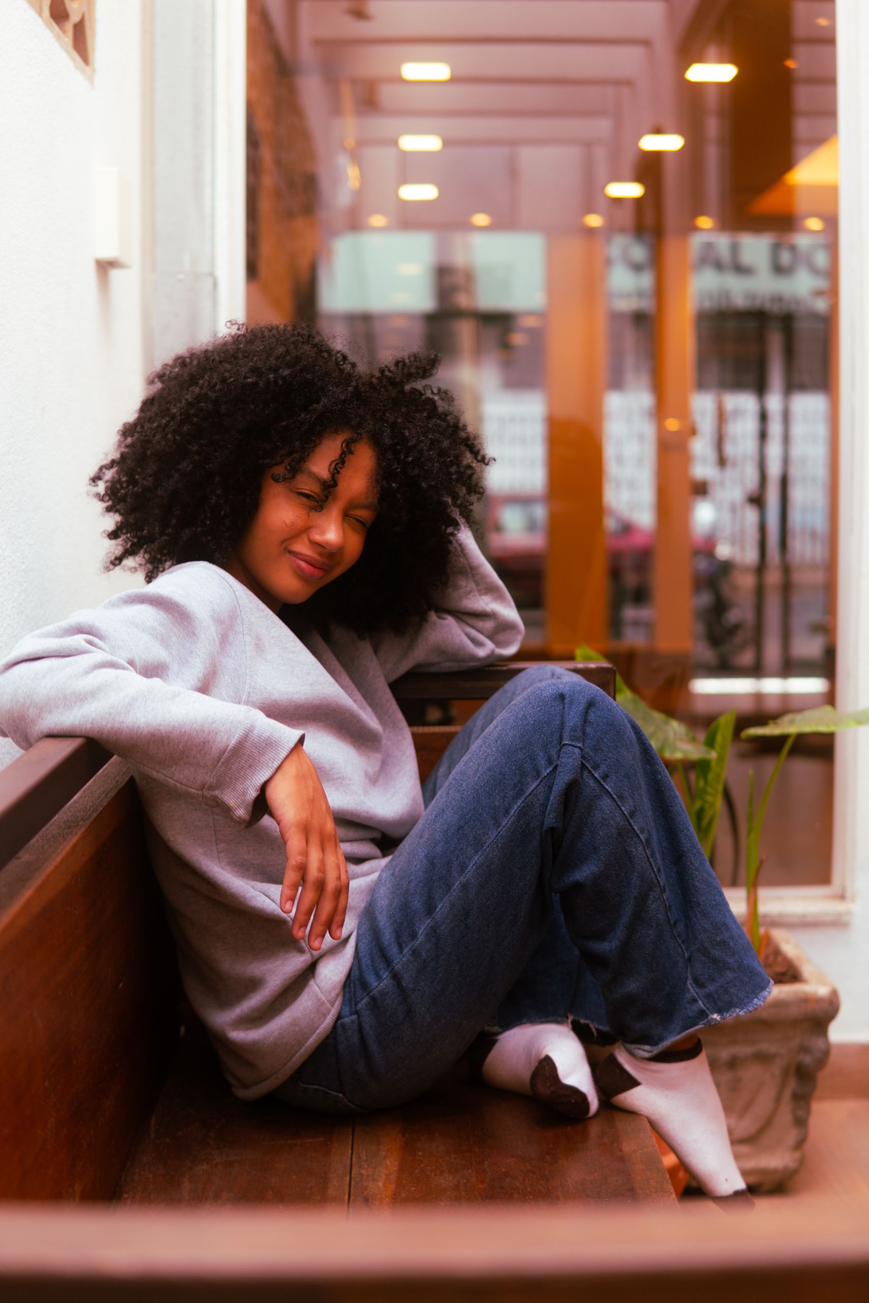 The Women Who Make Events Feel Effortless - The Women Who Make Events Feel Effortless - Woman relaxing casually on a bench indoors, exuding warmth and comfort.