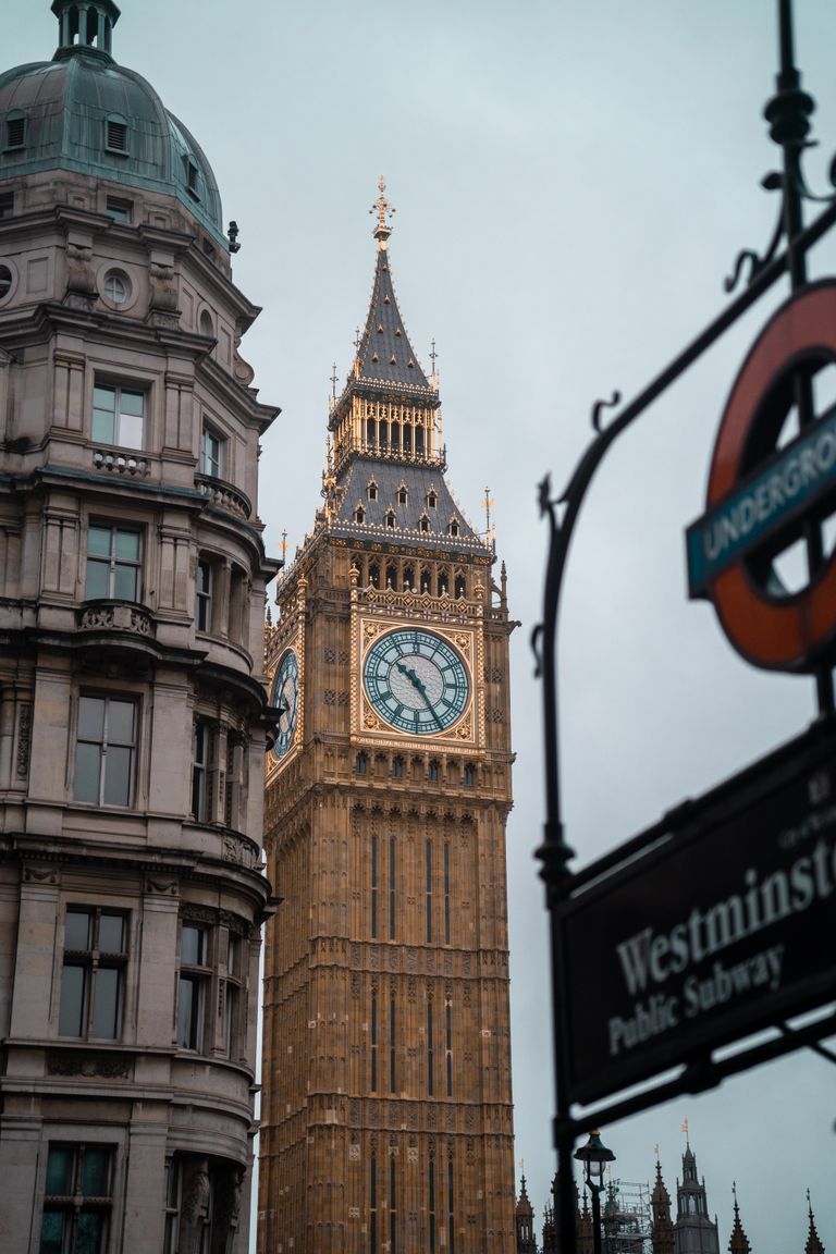 View of Big Ben tower next to the Westminster Subway sign in London, England.