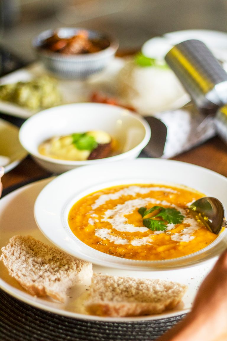 A Bookstore Tells Me What a City Wants to Remember - Warm and inviting bowl of creamy tomato soup garnished with cilantro, served with fresh bread.
