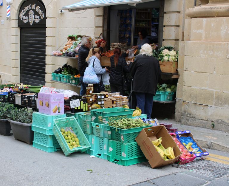 What a Food Market Reveals About a Place - Busy street market with people buying fresh produce from outdoor stalls.