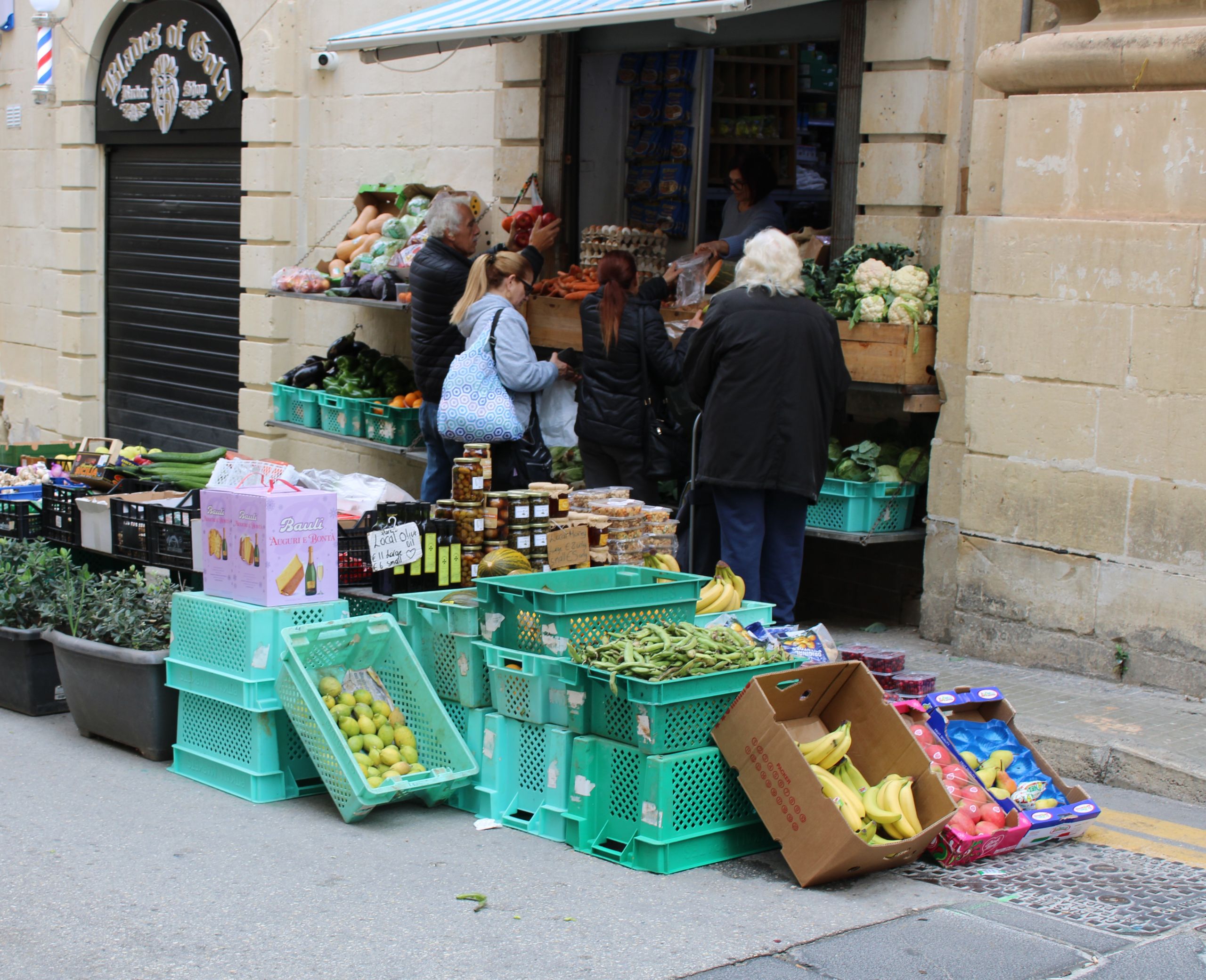 What a Food Market Reveals About a Place - Busy street market with people buying fresh produce from outdoor stalls.