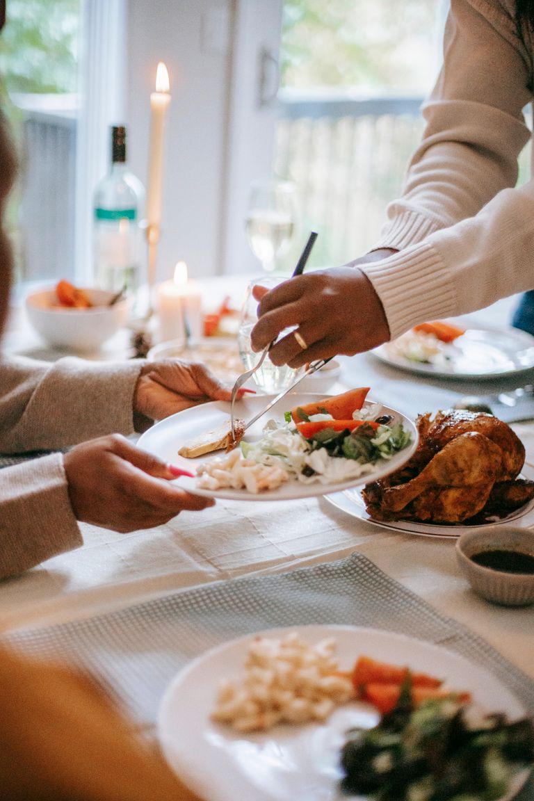 What a Second Serving Says About the Table - A festive Thanksgiving dinner being served with roast turkey and fresh salad on a table.