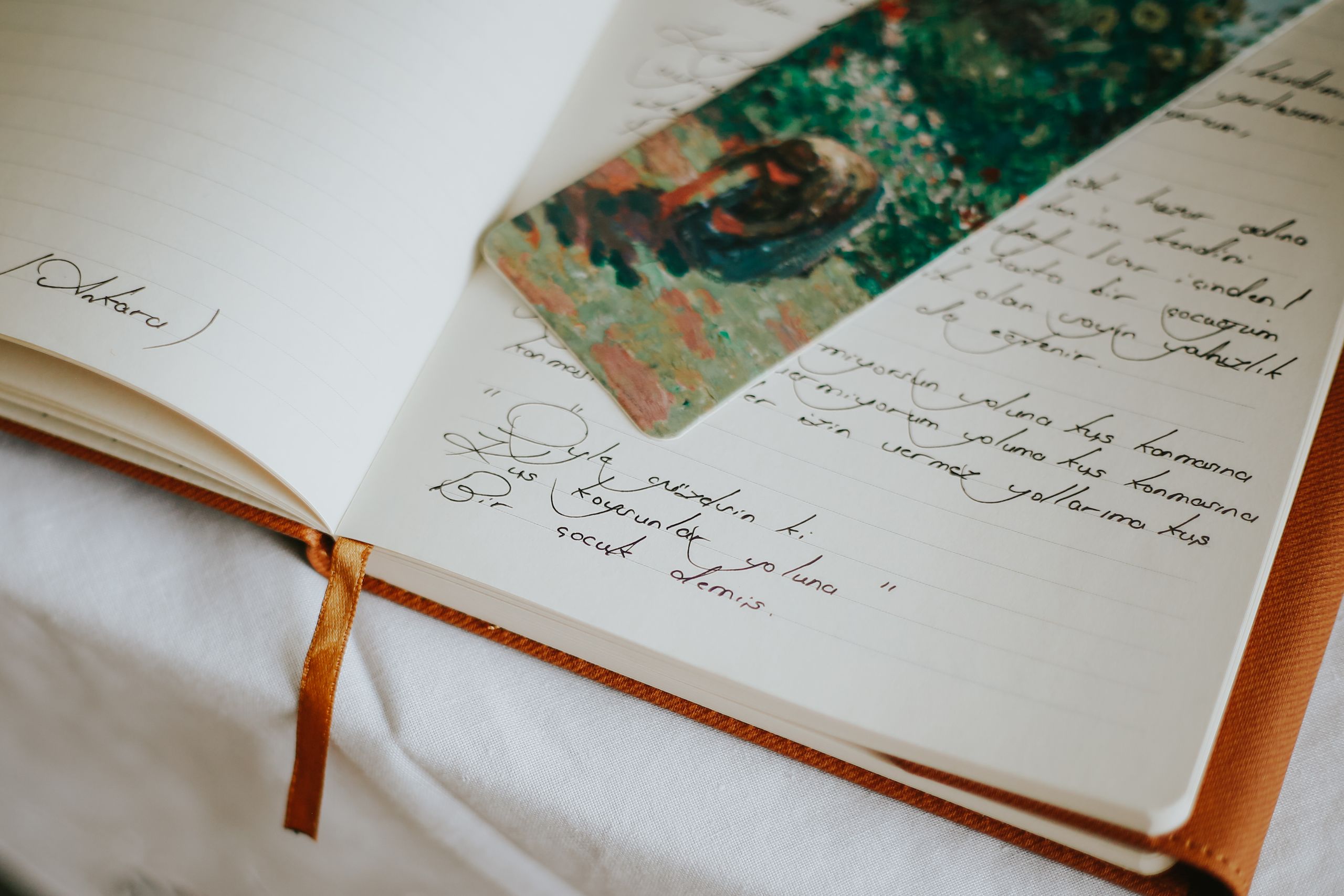 What a Year of Stories Can Teach - A close-up of an open journal with handwritten text and a colorful bookmark, evoking creativity.