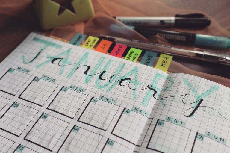 What I Want More of in the Year Ahead - Handwritten January planner page with tags and pens on a desk. Perfect for organizing schedules.
