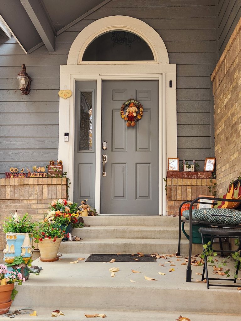 What Returning From Travel Teaches Me About Home - Cozy porch entrance adorned with autumn decor and colorful plants.