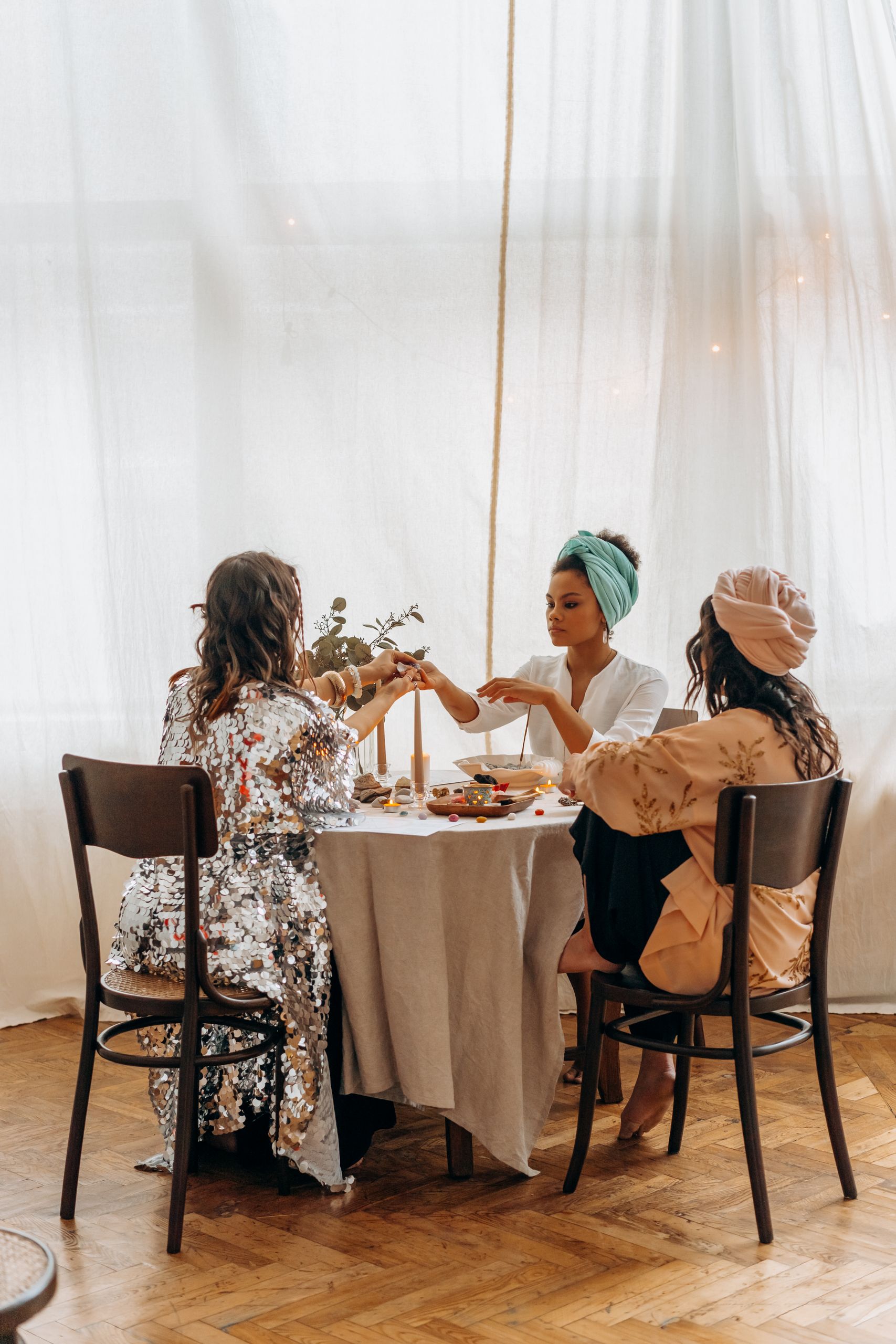 What Women Tell Each Other at the Table - Three women share a meal together at a round table in a cozy indoor setting.