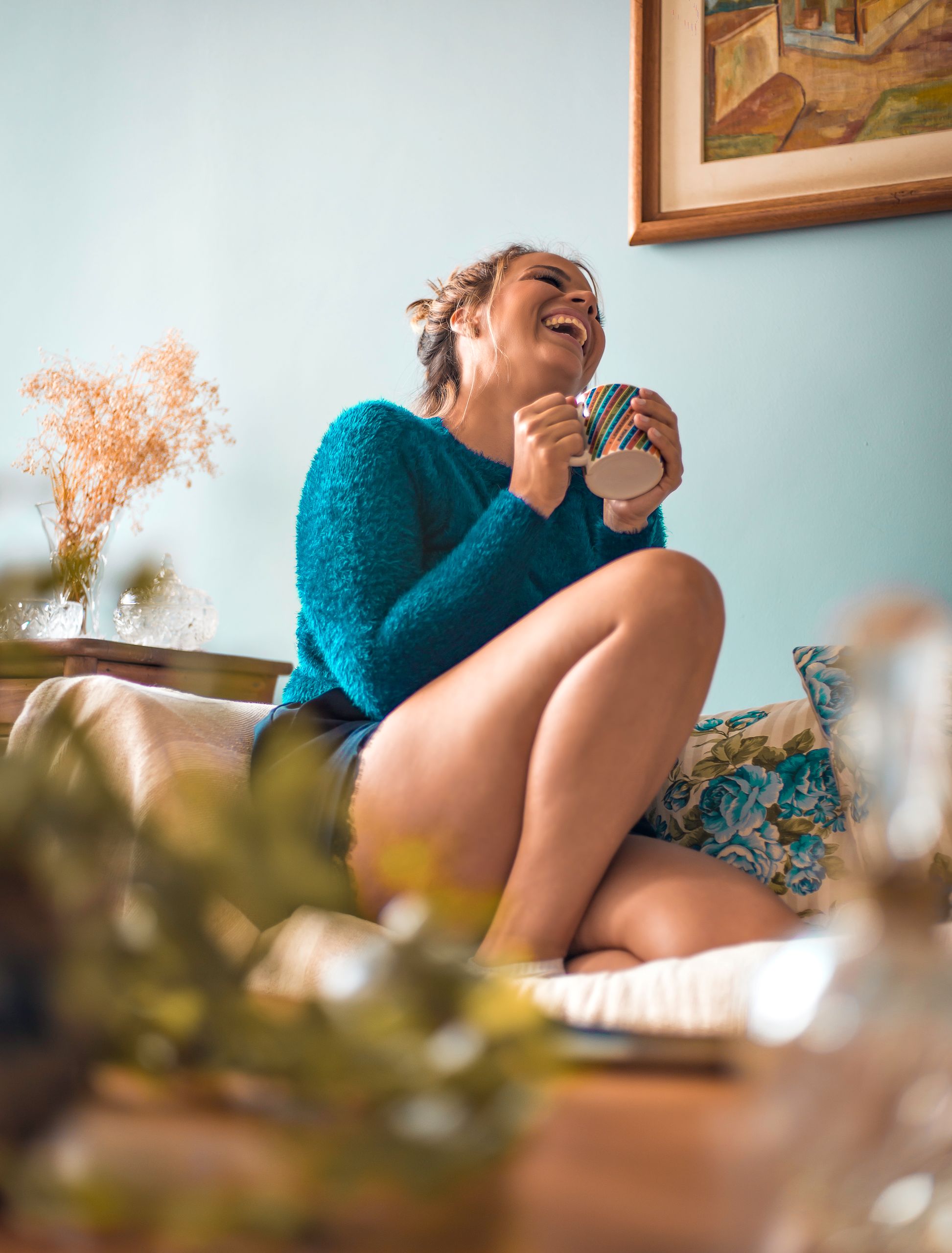 When Staying Close to Home Teaches Me More - From below of happy female with mug of beverage sitting on cozy couch at home
