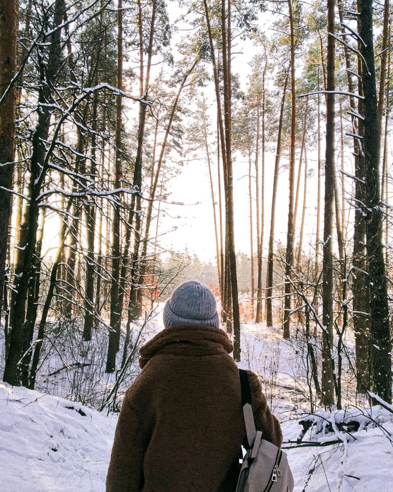 Why a Winter Walk Makes Me Feel More Alive - A bundled traveler explores a snowy forest in Kiev during winter.