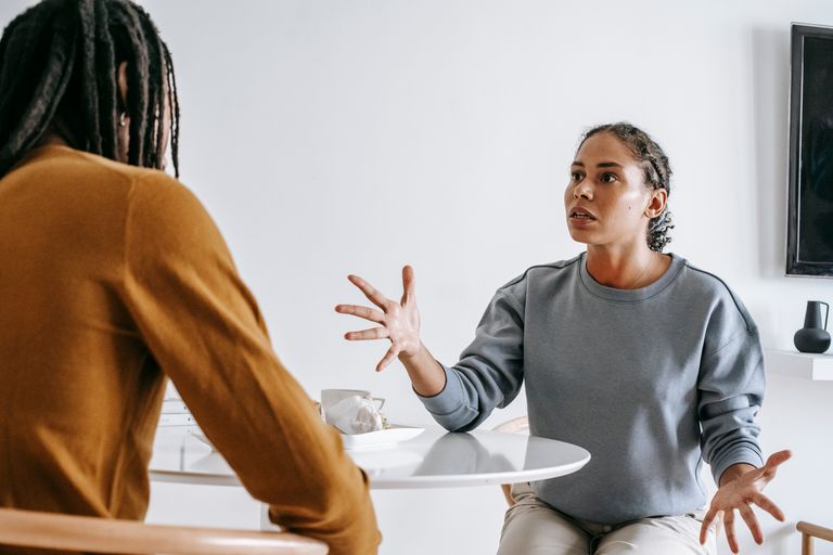 Why I Am Listening More Than I Am Explaining - Young black woman sitting at table with man and talking to each other in modern room