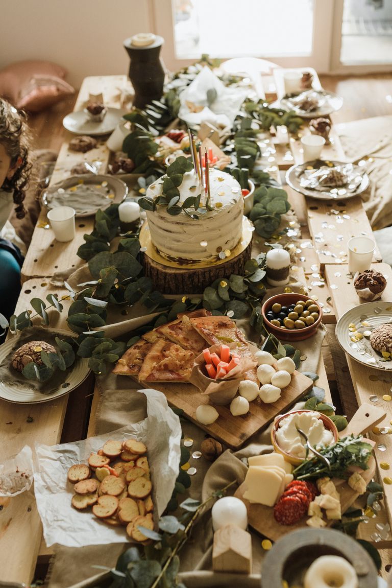Why I Want My Birthday Meals to Mean Something - A beautifully decorated rustic table set for a celebration with cakes and appetizers.