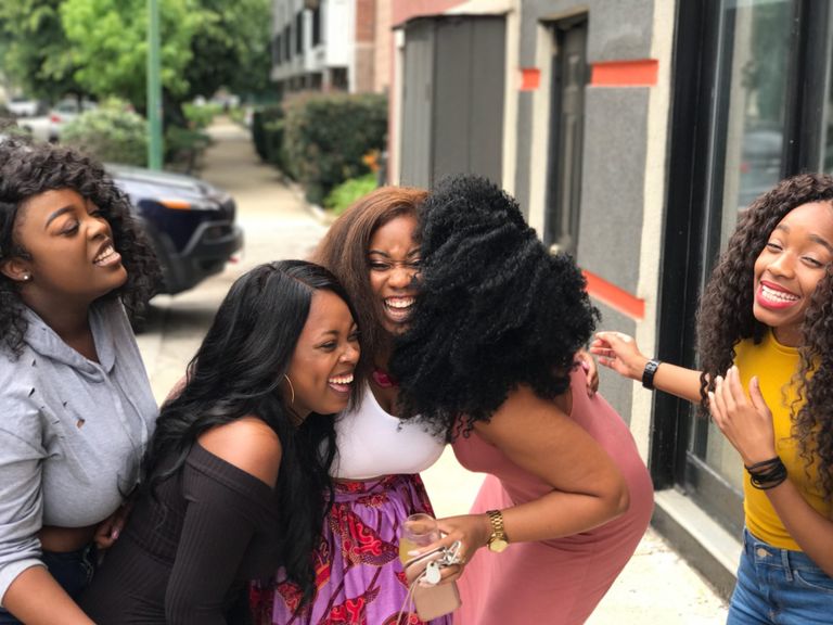 Why I Watch How People Make Room for Each Other - A joyful group of friends sharing a moment of laughter on a sunny day outdoors.