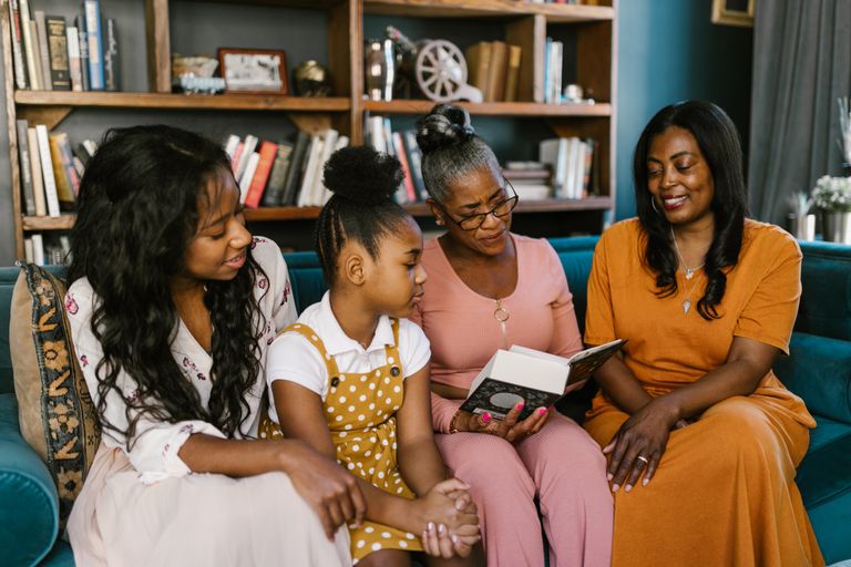 Why Women’s Stories Belong At The Center - A multigenerational family enjoys reading at home, sharing smiles and togetherness.