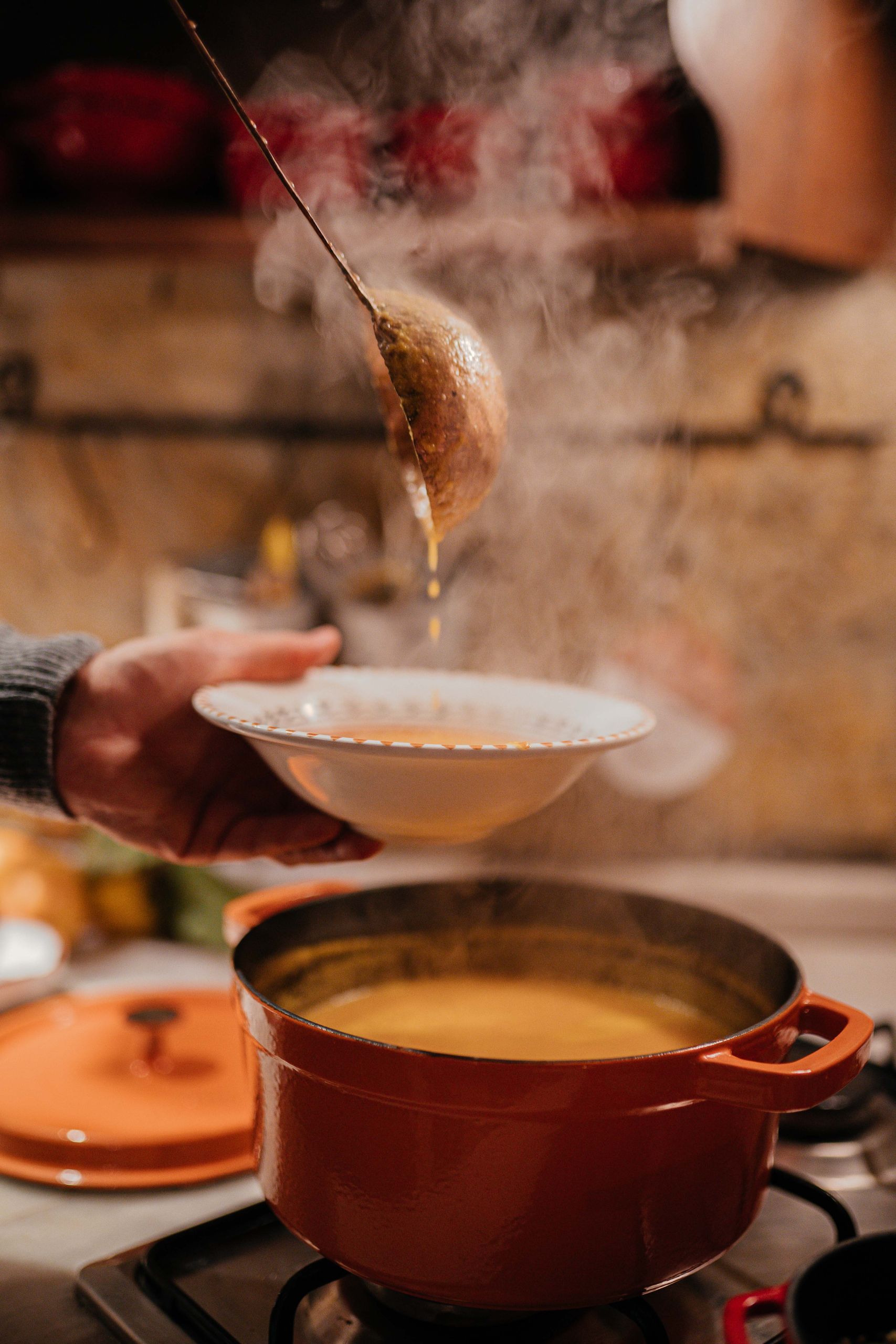 Winter Meal - Steamy bowl of hot soup being served in a cozy kitchen setting.