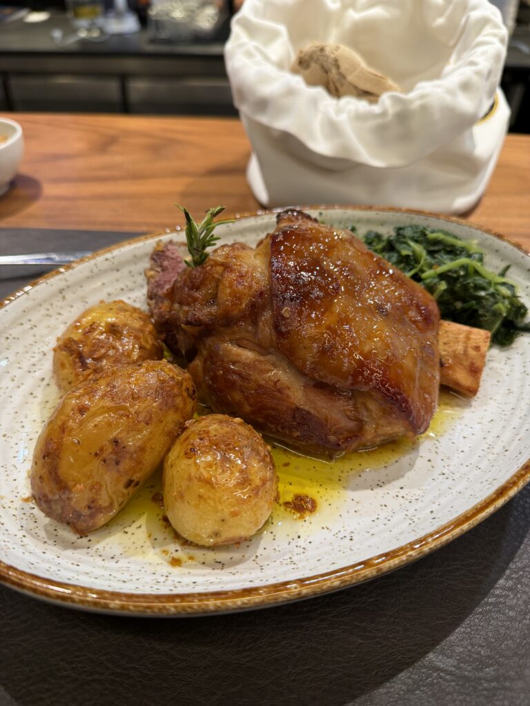 Pernil de porco with roasted potatoes and greens at Taberna do Paço in Braga, Portugal